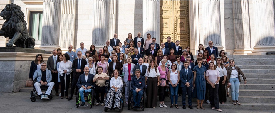 Representantes del movimiento asociativo, miembros del Congreso y responsables del Ministerio de Derechos, Consumo y Agenda 2030, posan en la escalinata del Congreso de los Diputados.